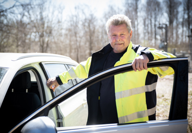 Elektriker som står vid sin servicebil