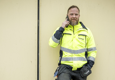 Elektriker som står vid sin servicebil