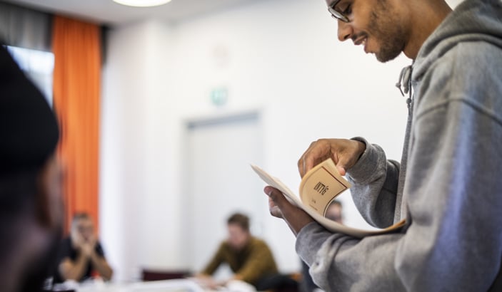 Ledare på en kurs som delar ut papper