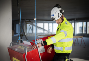 Elektriker med en hjälm på huvudet som arbetar på en byggarbetsplats