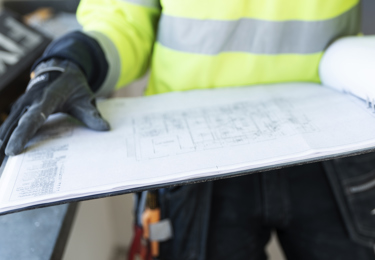 Två händer som håller i en pärm med en ritning