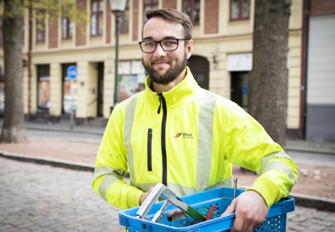 En service-elektriker med en verktygslåda under armen