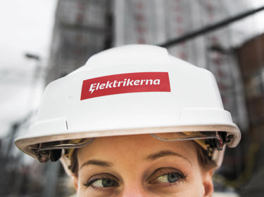 Elektriker i skyddshjälm med Elektrikernas logotyp på