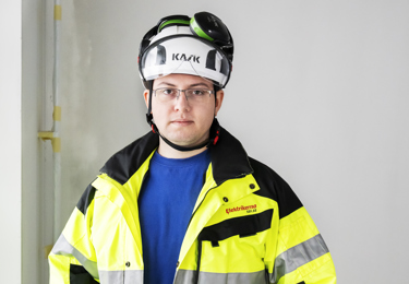 Elektriker som står ute i en trädgård täckt av snö