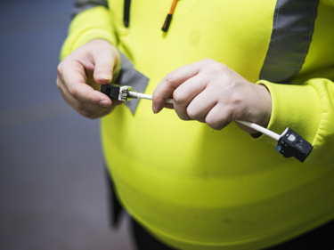 En gravid elektriker som håller i ett verktyg