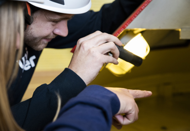 En elektriker som håller i en ficklampa