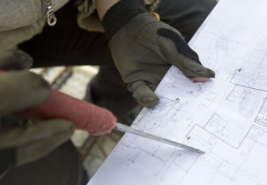 Hand i handskar som håller i en skruvmejsel