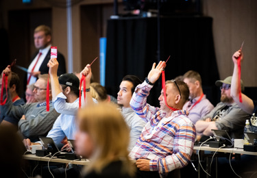 Deltagare vid Elektrikernas kongress 2022 som håller i röstningskort