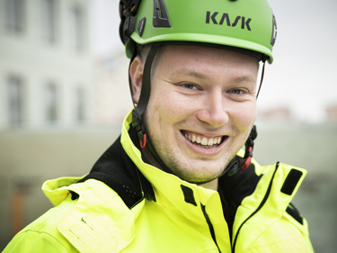 Fyra elektriker som står bredvid varandra iklädda gula varseljackor