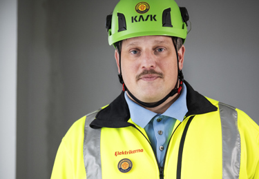 Elektriker i skyddskläder och skyddshjälm