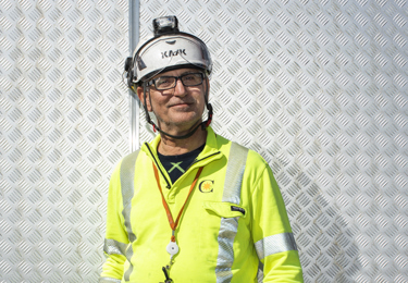 Elektriker iklädd varselkläder och hjälm.