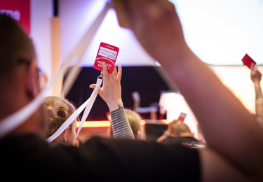 Händer som håller i röstkort på Svenska Elektrikerförbundets förbundsmöte 2018