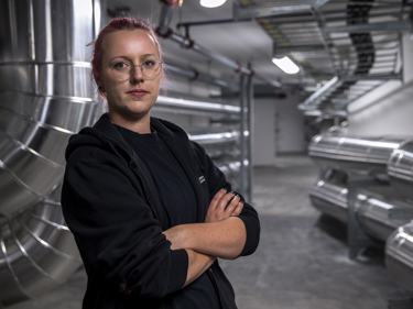 Elektriker som står med armarna i kors över bröstet och befinner sig i en kulvert